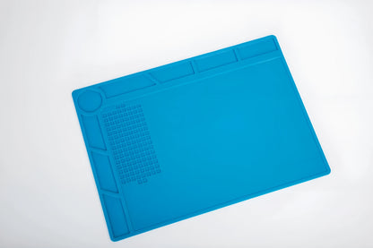 Blue silicone watch repair mat on workbench with watch tools