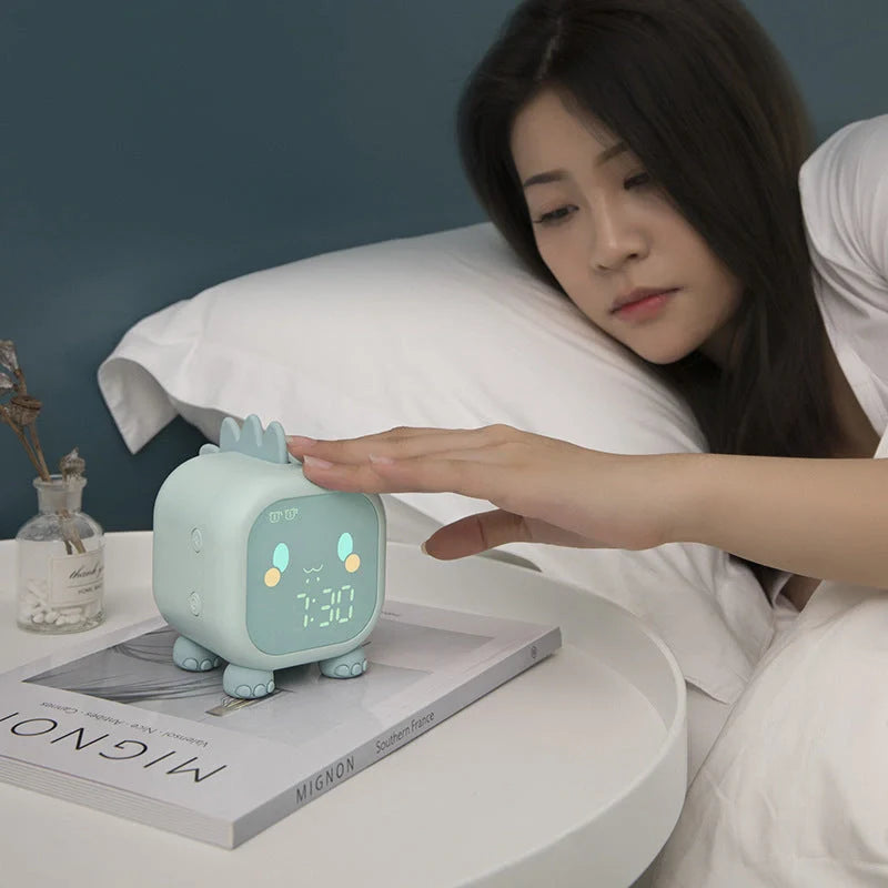 LED Cartoon Alarm Clock with voice control and digital display in pink, blue, green, and dinosaur designs