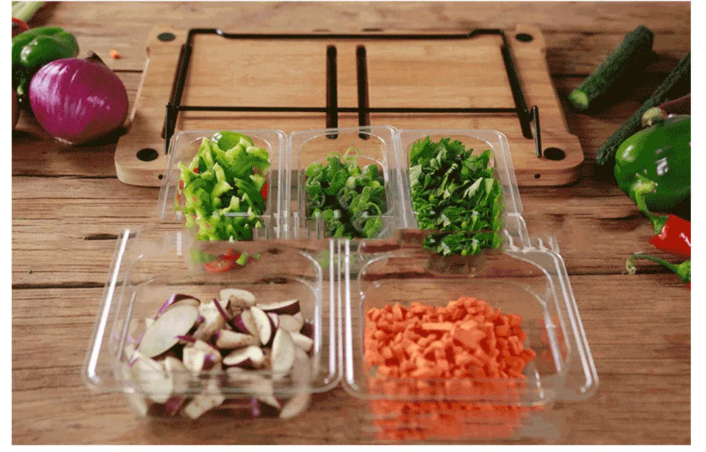 Bamboo cutting board with smooth surface alongside two large and three small plastic storage trays for vegetables and meat.