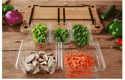 Bamboo cutting board with smooth surface alongside two large and three small plastic storage trays for vegetables and meat.