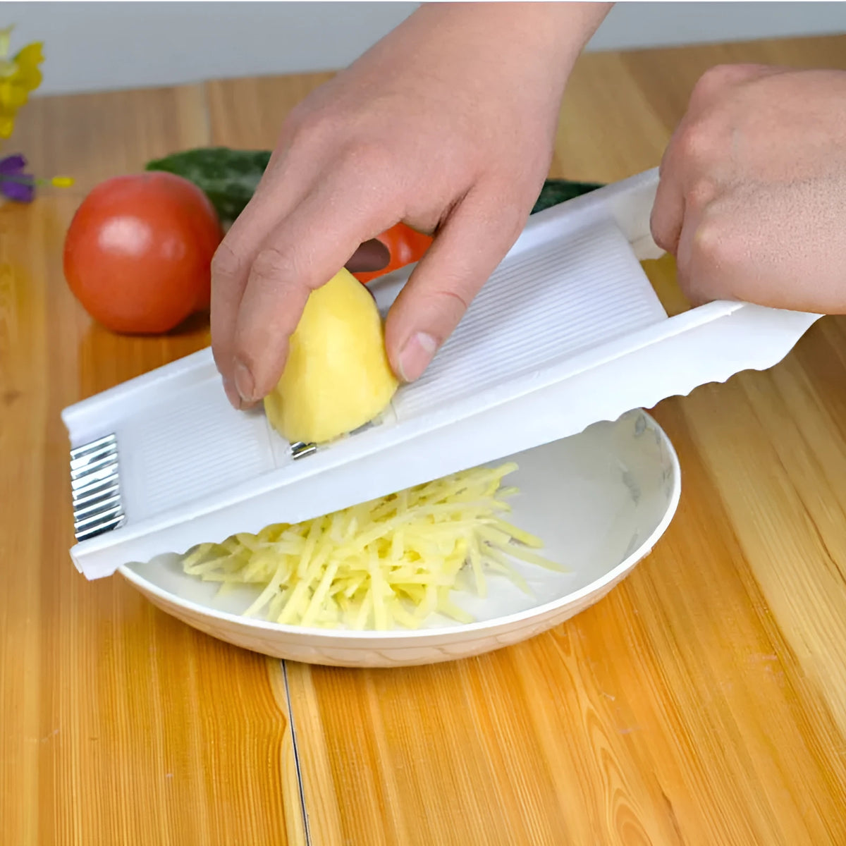 White five-piece stainless steel kitchen grater and vegetable slicer set with plastic hand guard