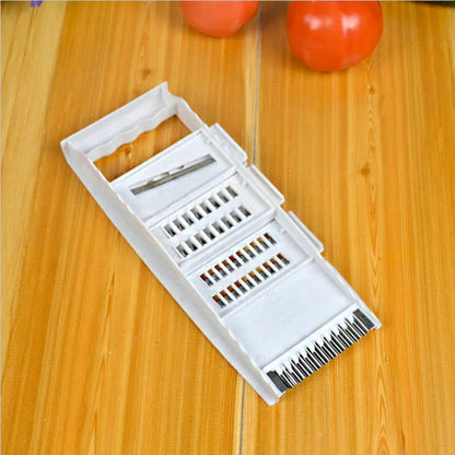 White five-piece stainless steel kitchen grater and vegetable slicer set with plastic hand guard