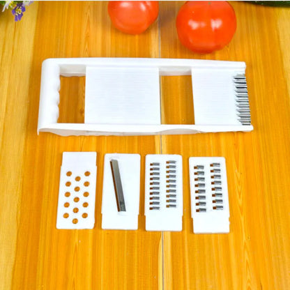 White five-piece stainless steel kitchen grater and vegetable slicer set with plastic hand guard