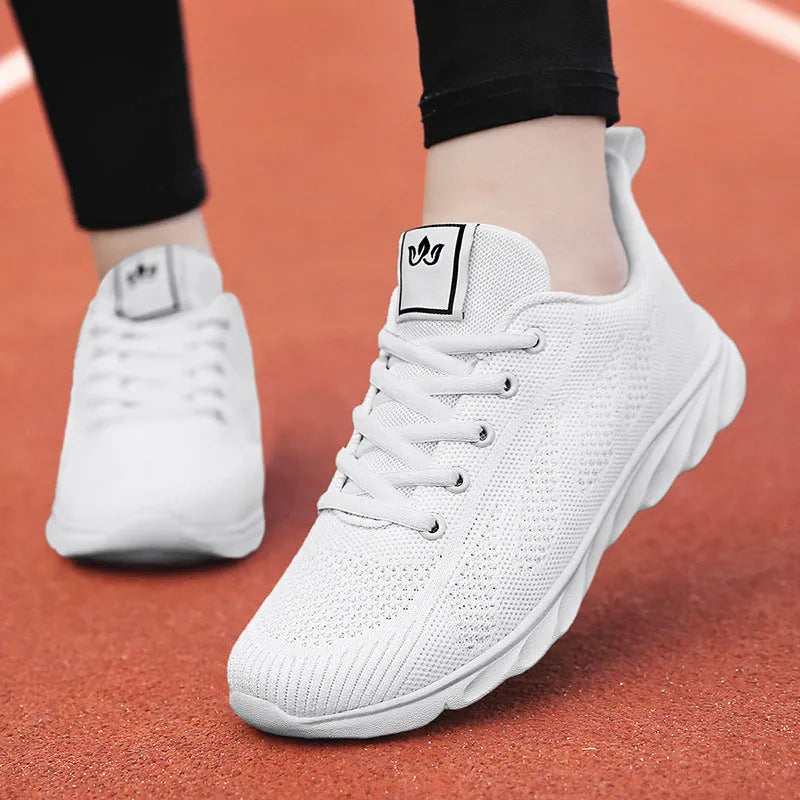 Women's white high-top trainers with cross-bind belt and hollow-out design on black background