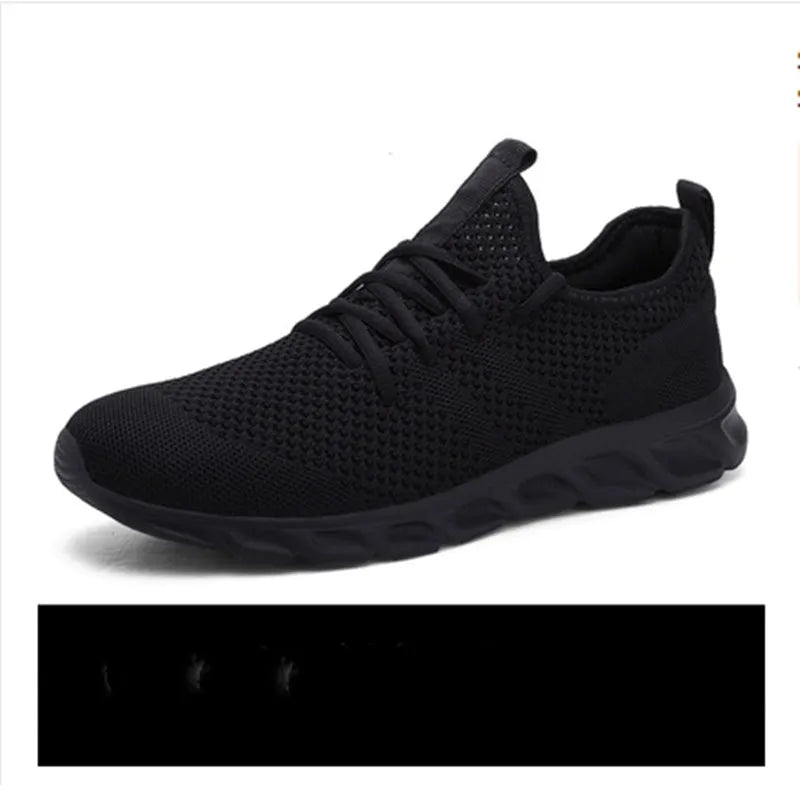 Men's black and white breathable mesh sneakers with round toe and lace-up closure on a grey background.