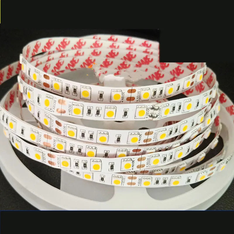 Close-up of flexible white LED light strip with 5050 SMD chips, showing cut points and adhesive backing.