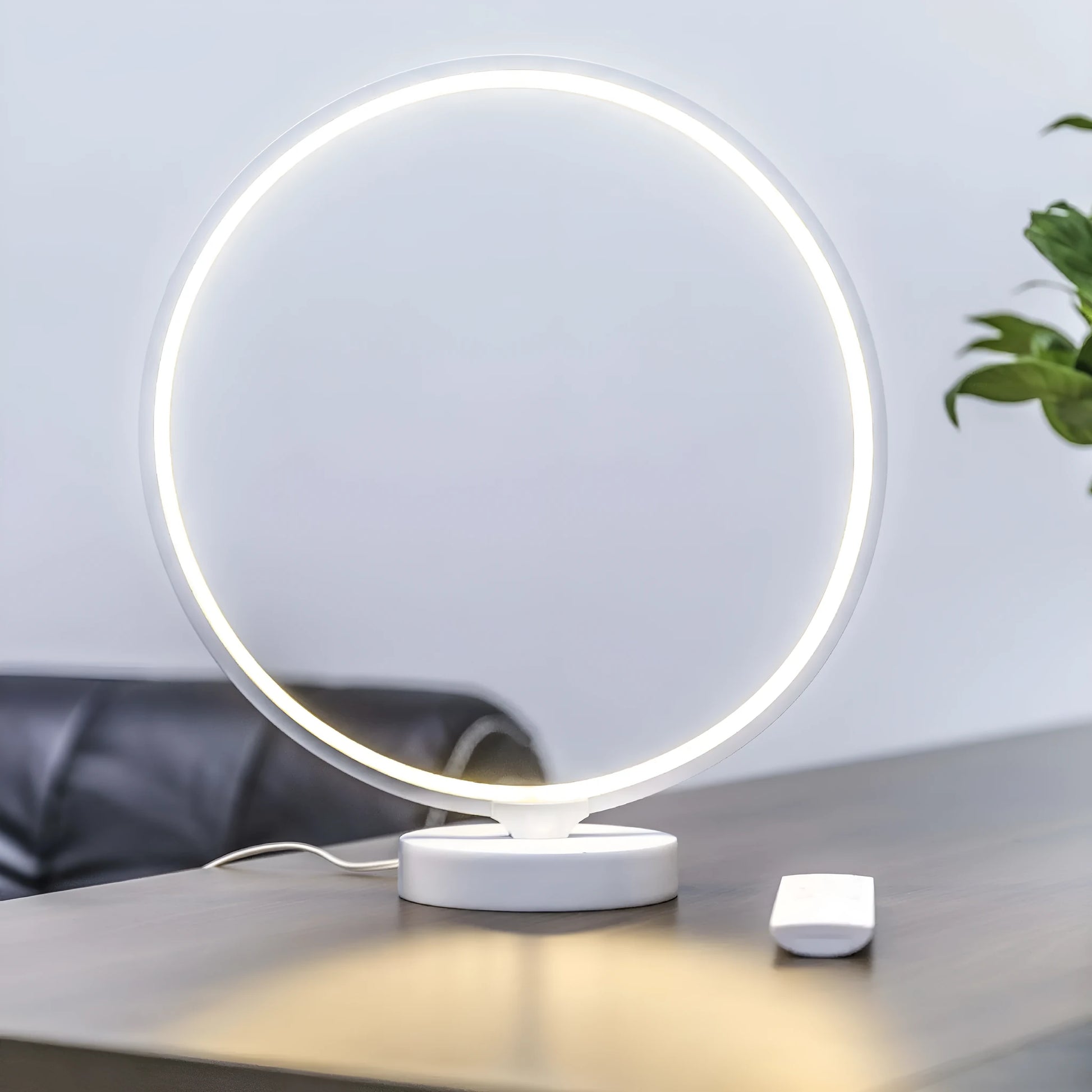 White full moon shaped table lamp with remote control on a table