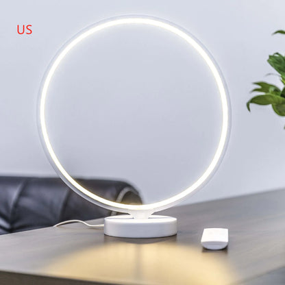 White full moon shaped table lamp with remote control on a table