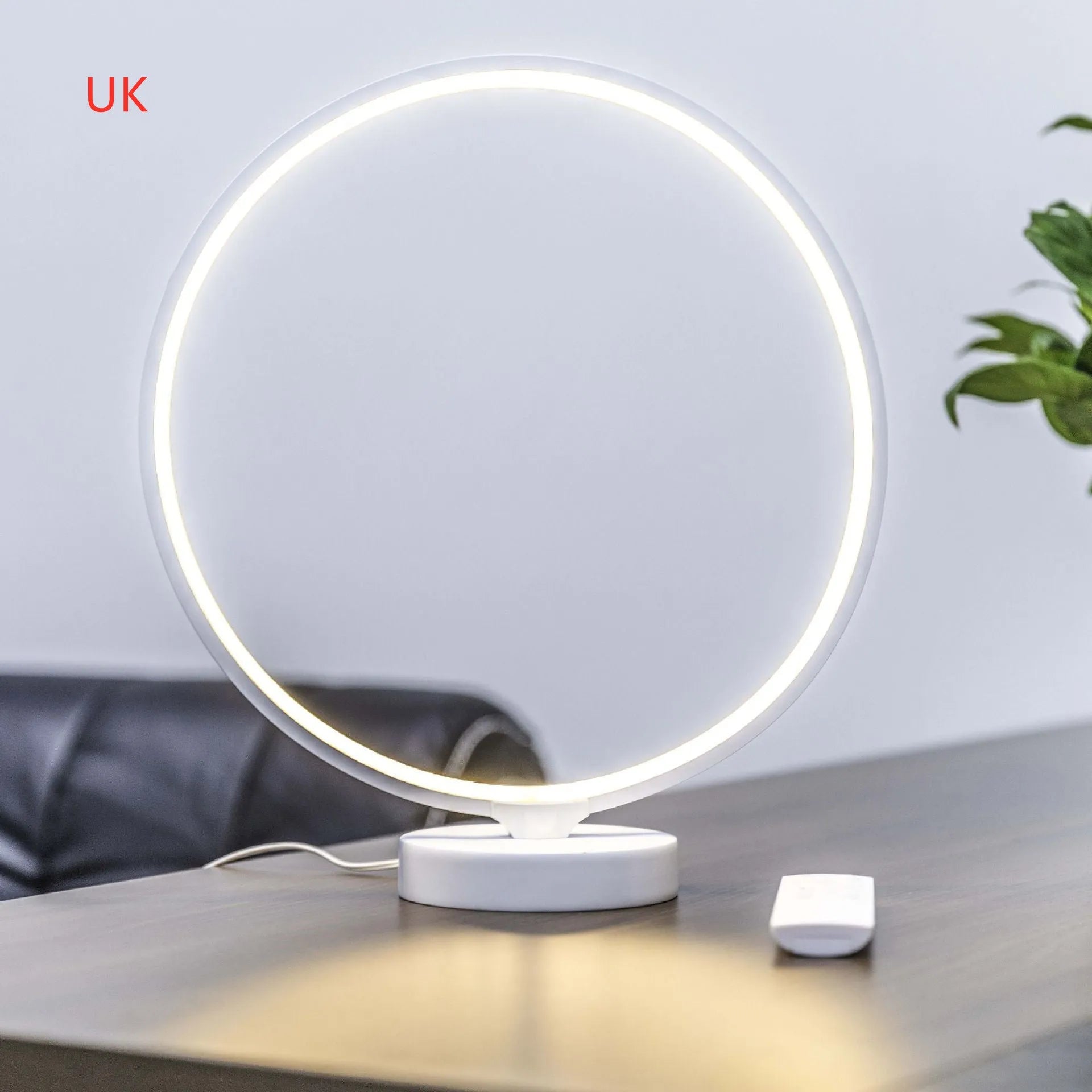 White full moon shaped table lamp with remote control on a table
