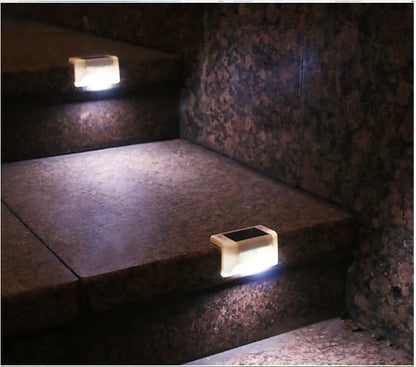 Set of four white solar-powered LED railing lights for outdoor steps and garden fences.