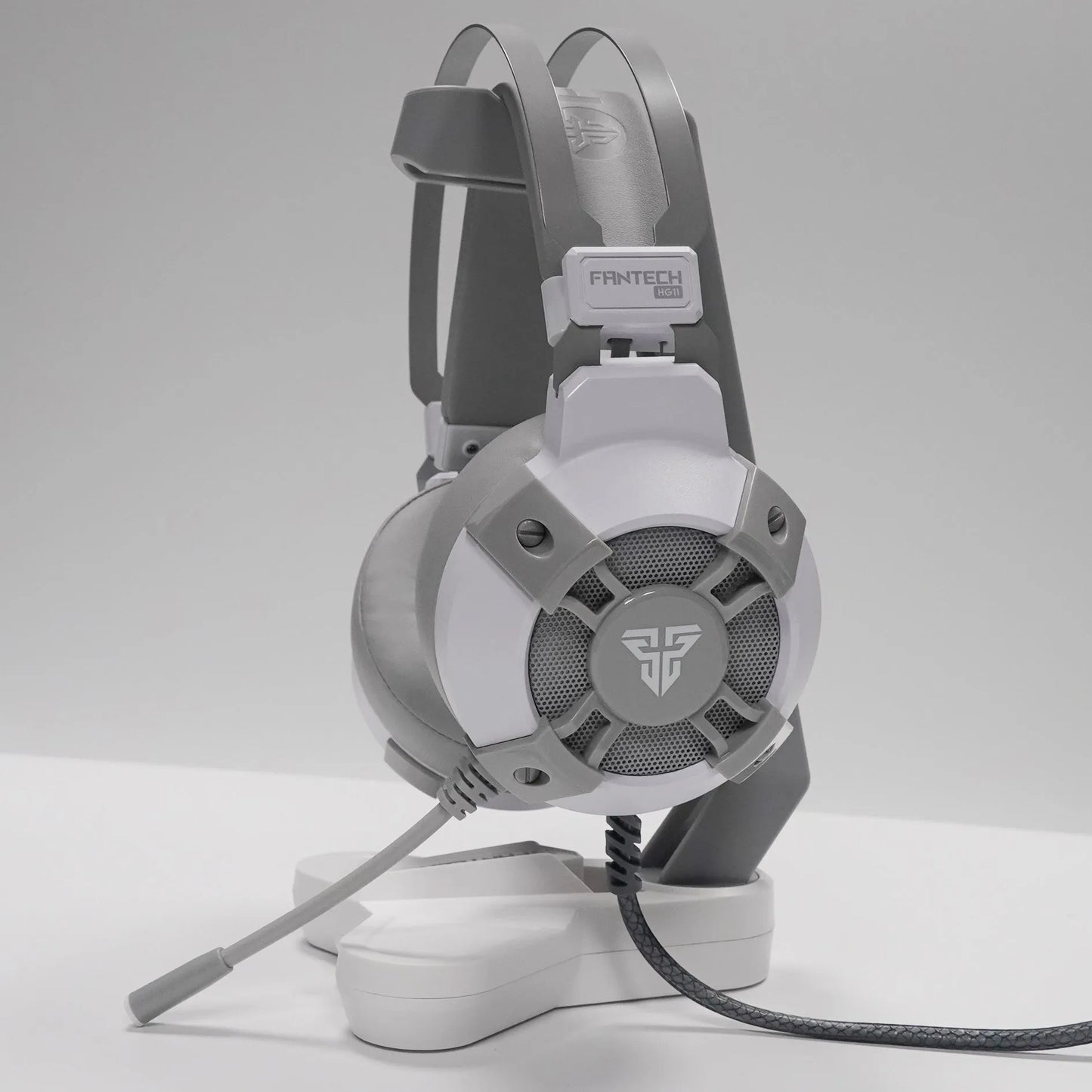 Black FANTECH HG11 USB gaming headset showing over-ear design, RGB lights on cups, and inline remote on cable.