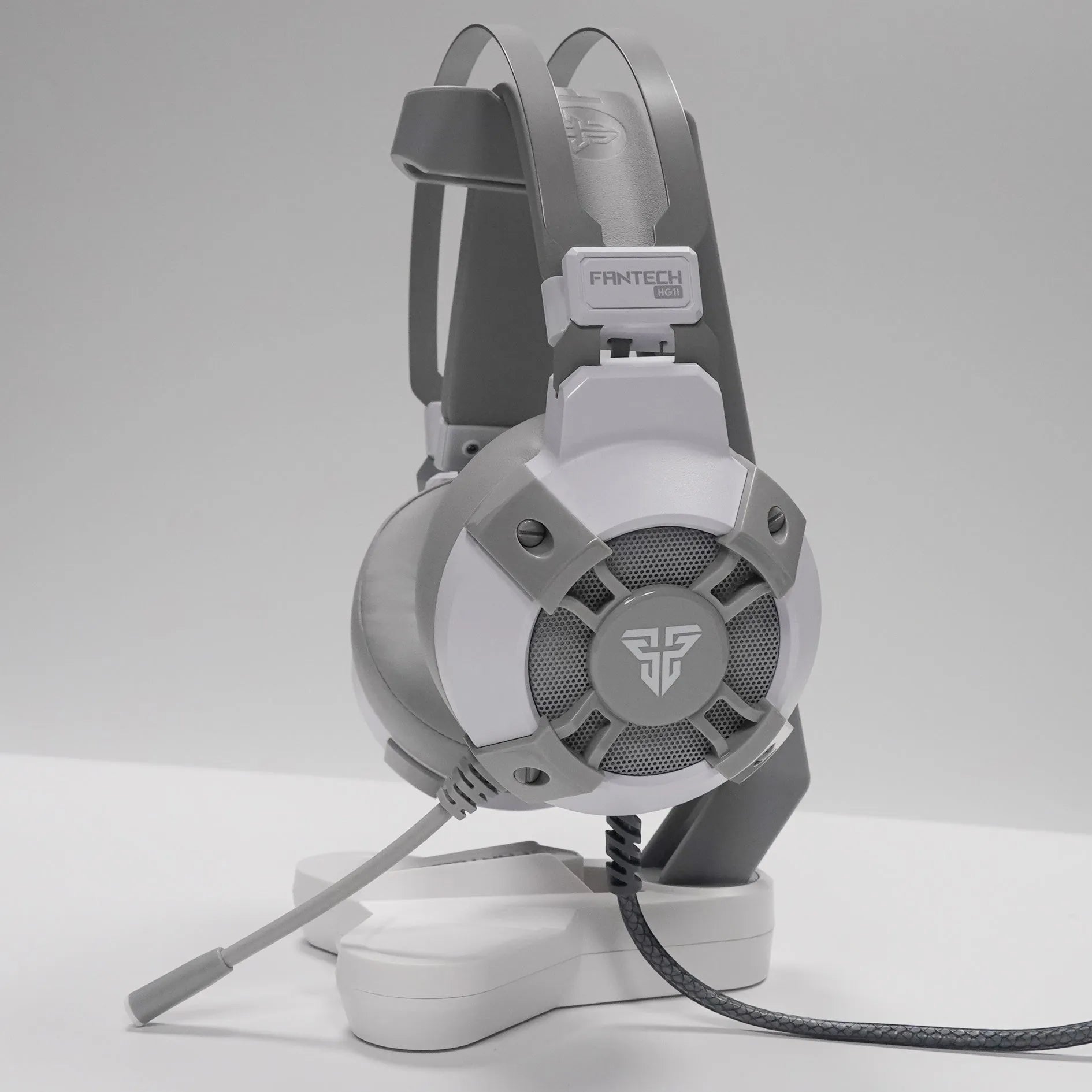 Black FANTECH HG11 USB gaming headset showing over-ear design, RGB lights on cups, and inline remote on cable.