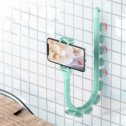 Black flexible rubber phone holder with suction cup extended on a desktop