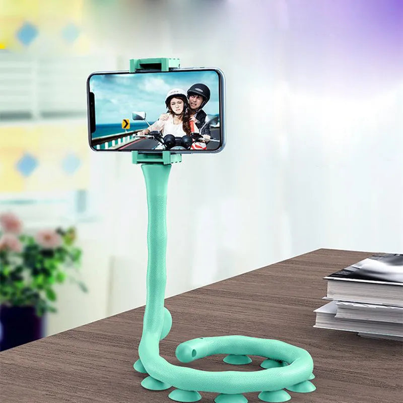 Black flexible gooseneck phone holder with suction cup base bent into an S-shape, holding a smartphone.