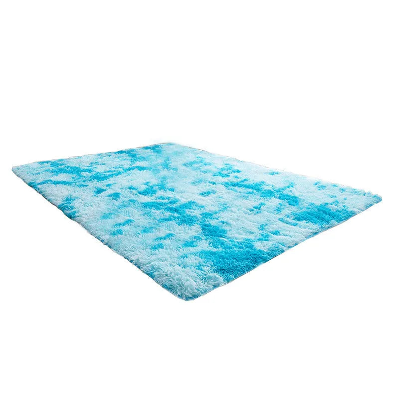Soft fluffy plain rectangle carpet with anti-slip dots on backing, shown in a light grey colour on a wooden floor.