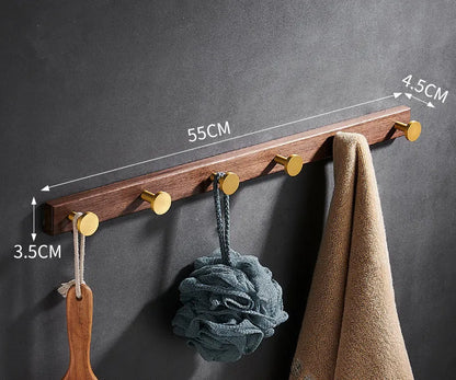 Black walnut wood clothes hooks with brass-finished aluminium frame in a 4-hook wall-mounted style