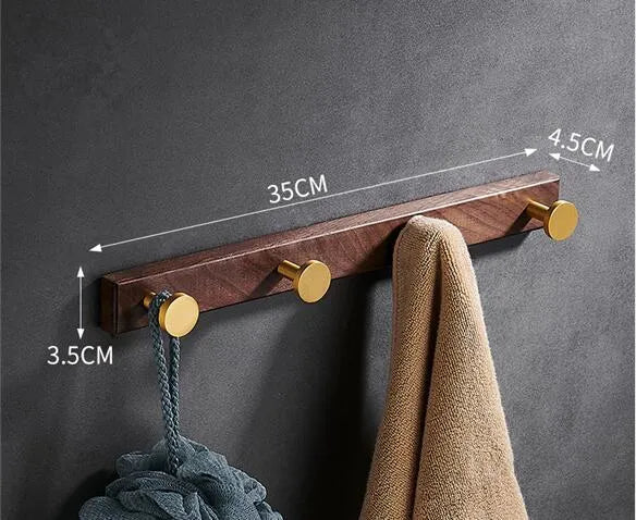 Black walnut wood clothes hooks with brass-finished aluminium frame in a 4-hook wall-mounted style