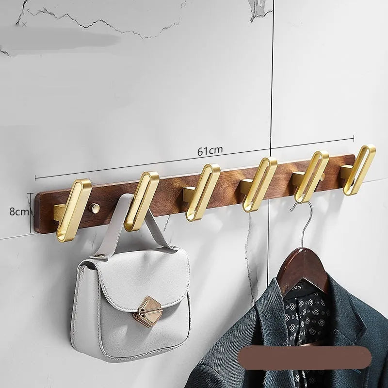 Black walnut wood clothes hooks with brass-finished aluminium frame in a 4-hook wall-mounted style