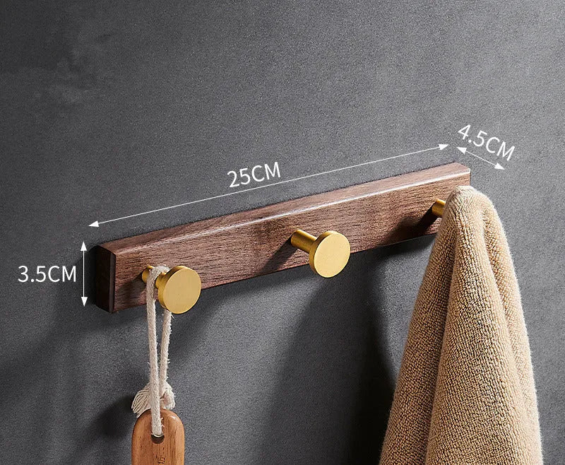 Black walnut wood clothes hooks with brass-finished aluminium frame in a 4-hook wall-mounted style