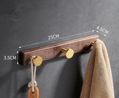 Black walnut wood clothes hooks with brass-finished aluminium frame in a 4-hook wall-mounted style