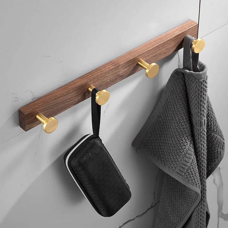 Black walnut wood clothes hooks with brass-finished aluminium frame in a 4-hook wall-mounted style
