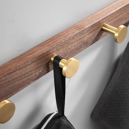 Black walnut wood clothes hooks with brass-finished aluminium frame in a 4-hook wall-mounted style