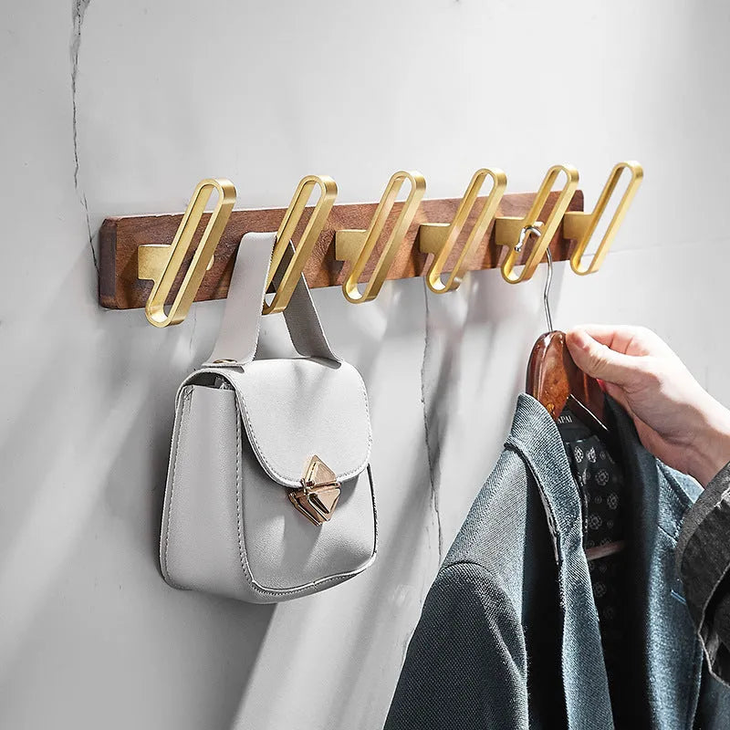 Black walnut wood clothes hooks with brass-finished aluminium frame in a 4-hook wall-mounted style