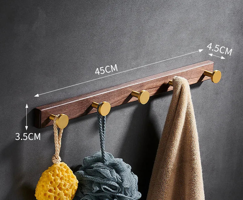 Black walnut wood clothes hooks with brass-finished aluminium frame in a 4-hook wall-mounted style