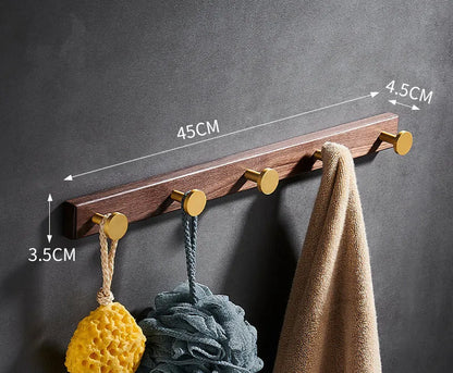 Black walnut wood clothes hooks with brass-finished aluminium frame in a 4-hook wall-mounted style