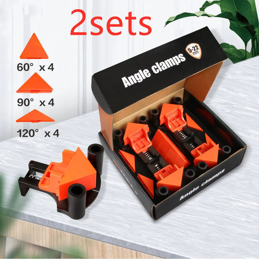 Four white plastic right angle clamps for woodworking and picture frame assembly on a workbench.
