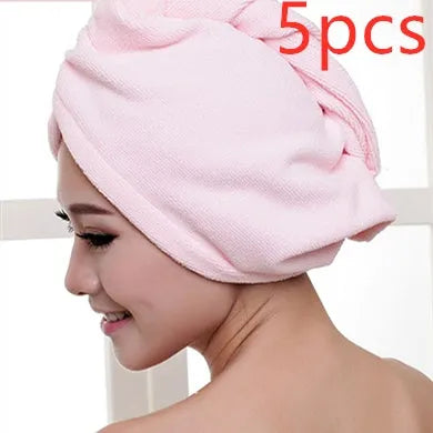 A woman wearing a sky blue microfiber hair dryer cap, with wet hair tucked inside, showing the towel's wrap-around design.