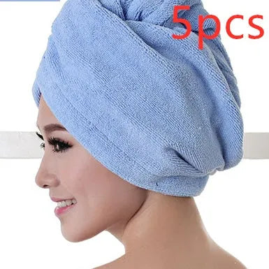 A woman wearing a sky blue microfiber hair dryer cap, with wet hair tucked inside, showing the towel's wrap-around design.