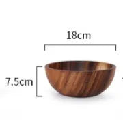 Set of five brown wooden bowls in different sizes on a wooden table, showing natural grain.