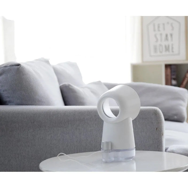 White round desktop humidifier with leafless fan, USB cable, and single mist outlet on a desk