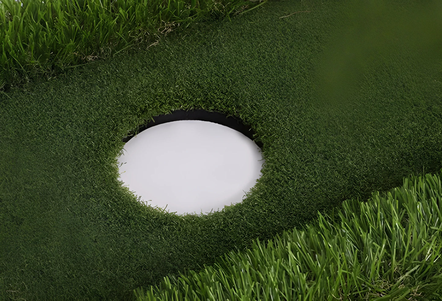 Green golf training mat on floor showing artificial grass surface and thick EVA foam base edge.