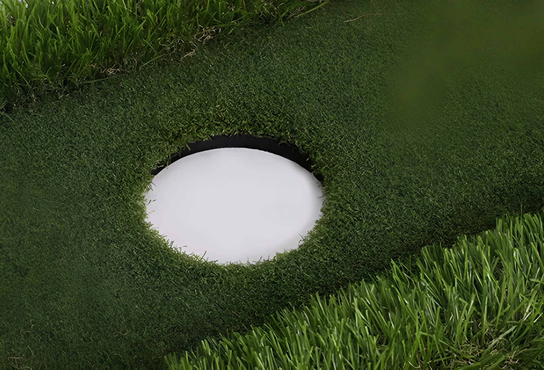 Green golf training mat on floor showing artificial grass surface and thick EVA foam base edge.