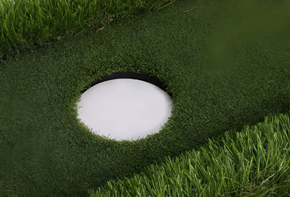 Green golf training mat on floor showing artificial grass surface and thick EVA foam base edge.
