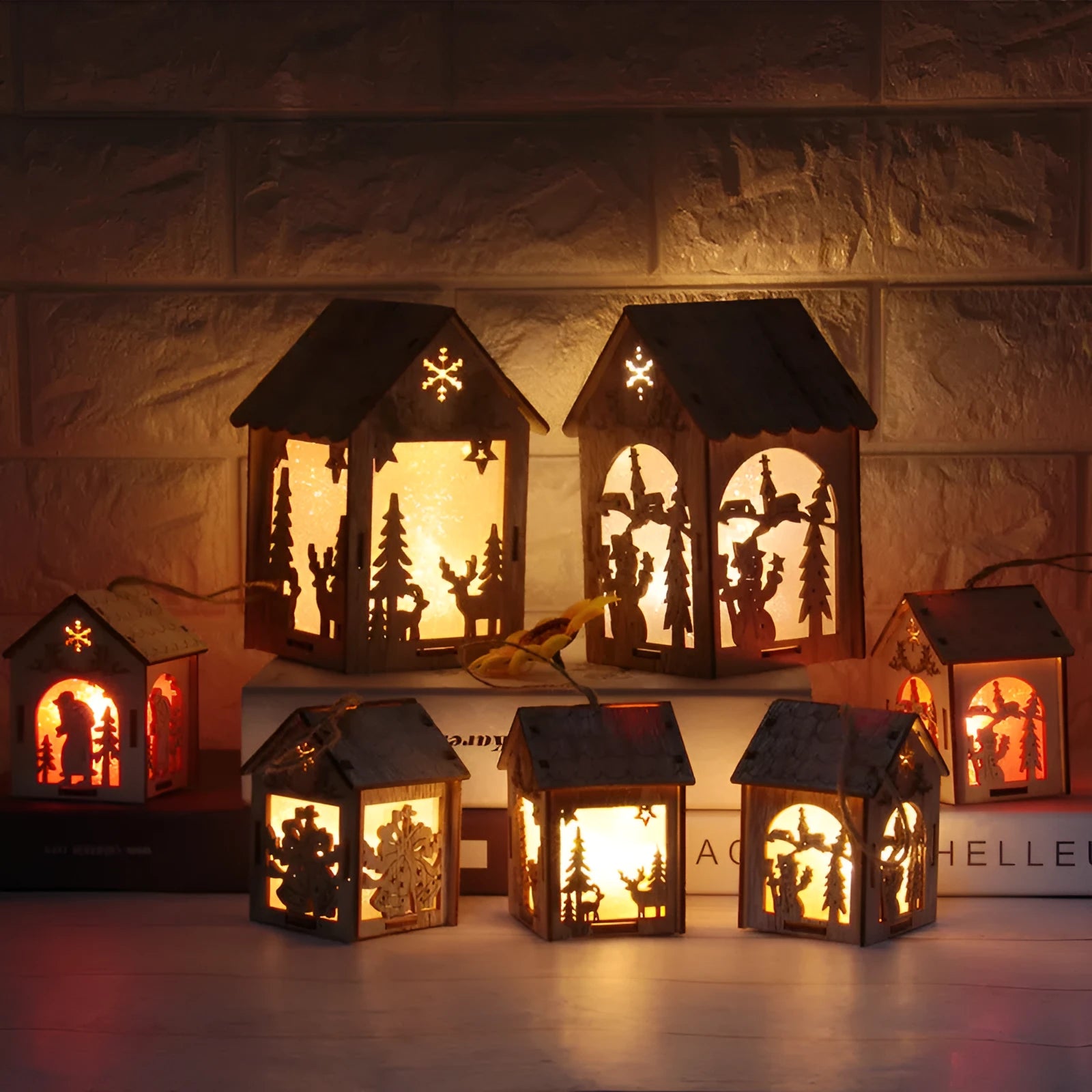 Three wooden Christmas house decorations: a small bell, a Santa Claus house, and a snowman house on a festive backdrop.