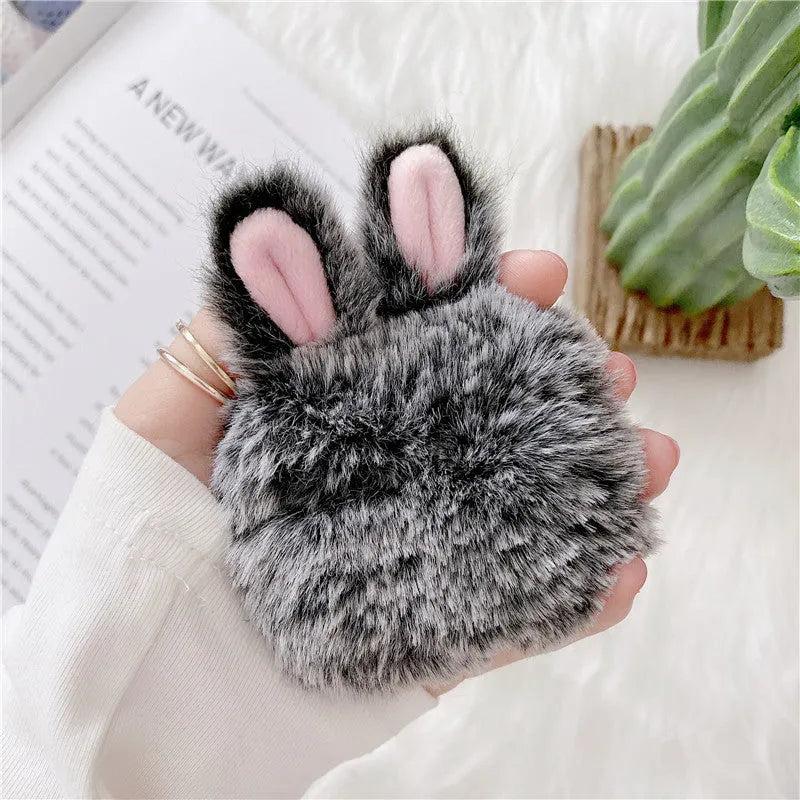Pink silicone AirPods case cover with raised rabbit ears, placed next to grey version