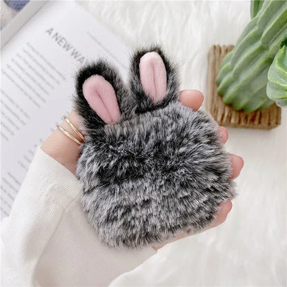 Pink silicone AirPods case cover with raised rabbit ears, placed next to grey version