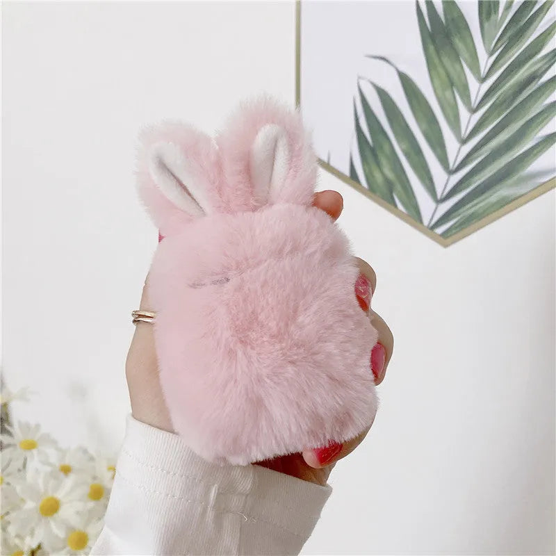 Pink silicone AirPods case cover with raised rabbit ears, placed next to grey version