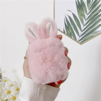 Pink silicone AirPods case cover with raised rabbit ears, placed next to grey version