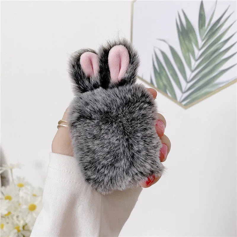 Pink silicone AirPods case cover with raised rabbit ears, placed next to grey version