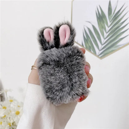 Pink silicone AirPods case cover with raised rabbit ears, placed next to grey version