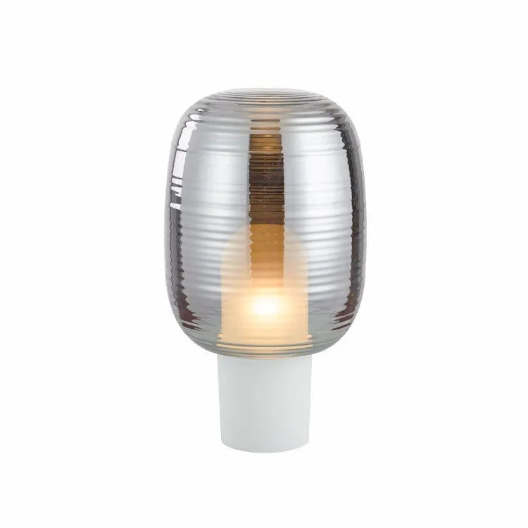 Glass table lamp with LED light source features a simple modern Nordic style design available in cognac or smoky grey colour options with push button switch control for living room or bedroom use