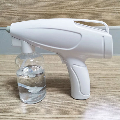 White handheld cordless electric spray disinfection gun with USB-C port and trigger, showing mist spray.