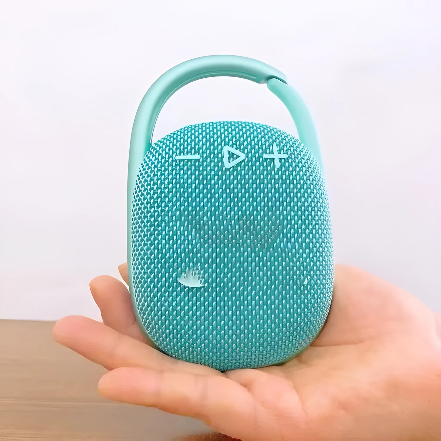 Compact 4th generation wireless Bluetooth speaker in silver grey colour with fabric grille on a wooden table.