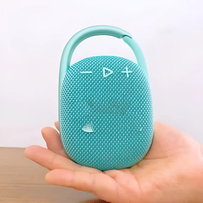 Compact 4th generation wireless Bluetooth speaker in silver grey colour with fabric grille on a wooden table.