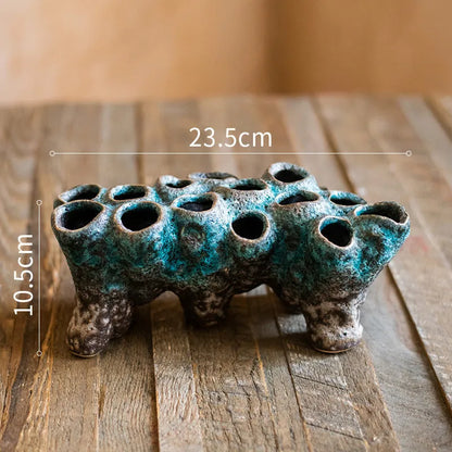 Medium-sized ceramic Barnacle Vase with porous flower design in new Chinese style, on a table.