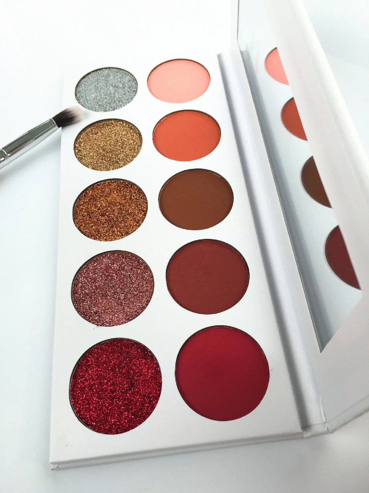 Eyeshadow palette showing 10 different colour shades in standard compact